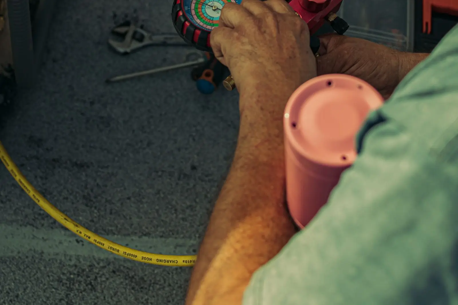 Close-up of hands holding HVAC refrigerant pressure gauges